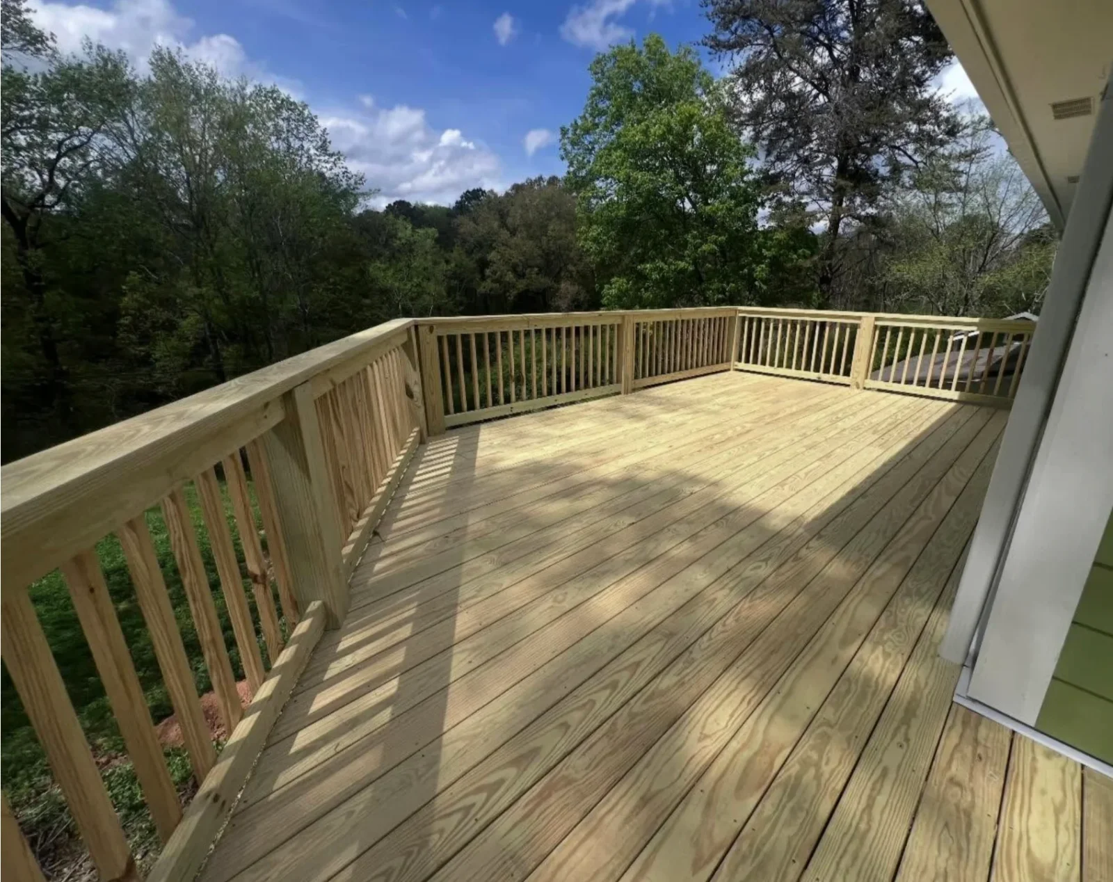 New pressure-treated pine deck with vertical baluster railing and square newel posts